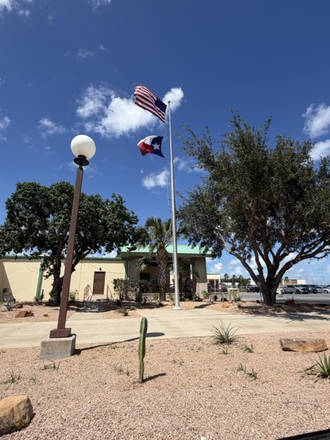 U.S. and Texas flags snapping in the wind over a Rio Grande Valley property — G-Uprooted Tree Services responds 24/7 when storms put trees at risk